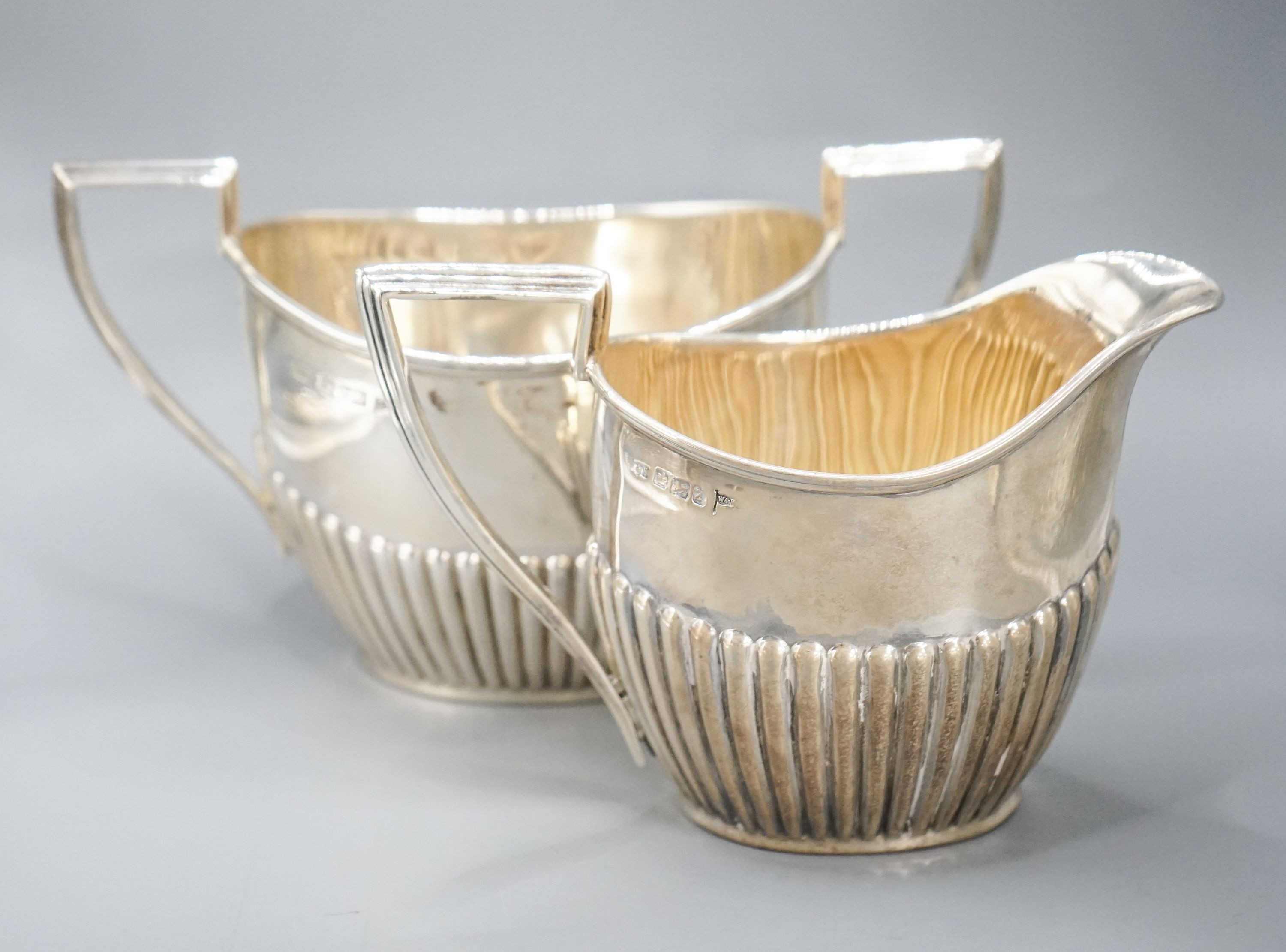 A late Victorian fluted silver cream jug and matching sugar bowl, by Walker & Hall, Sheffield, 1892/3, 13oz.